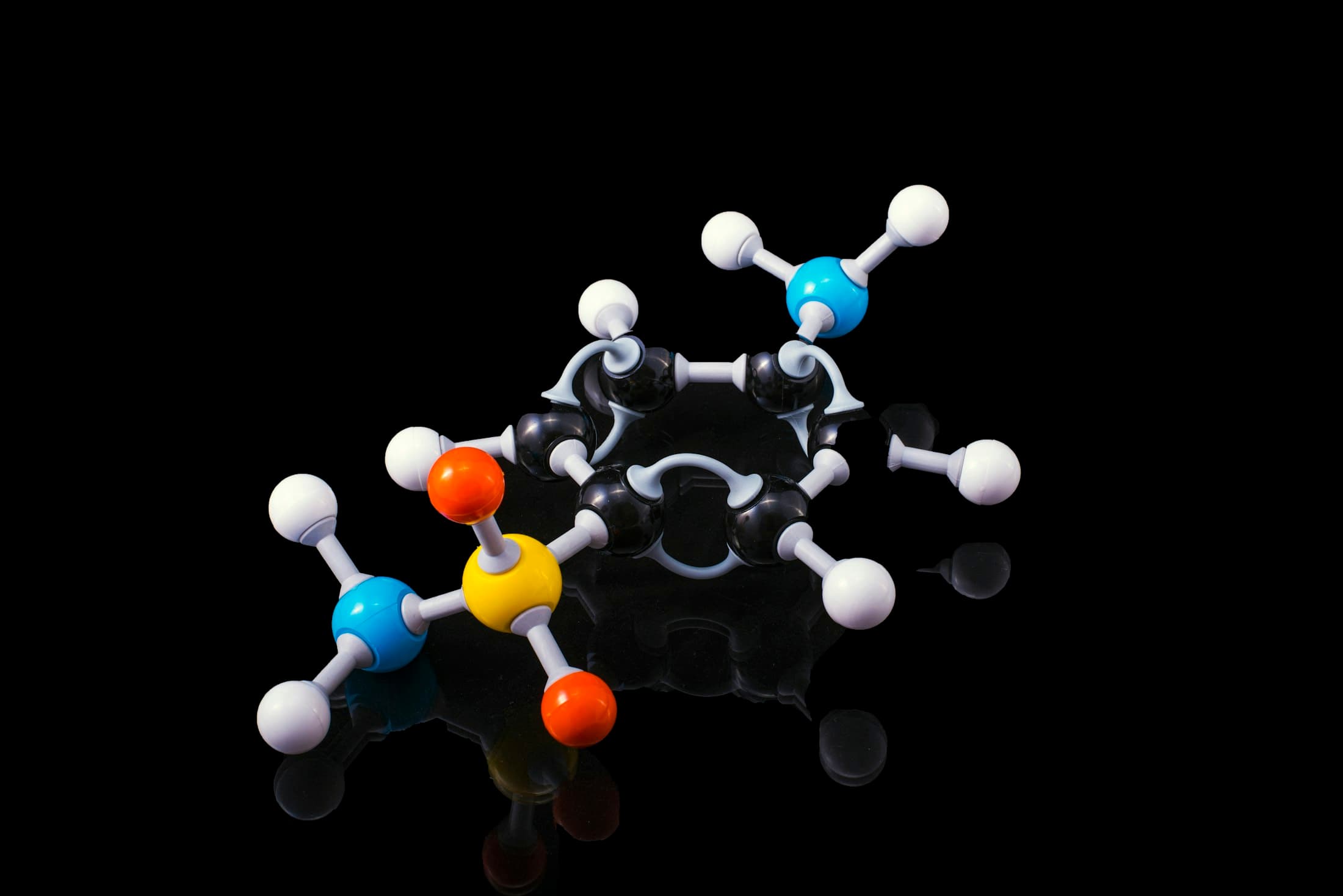 A molecular model with coloured atoms on black